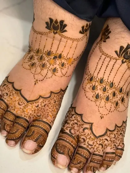 A delicate and modern foot design, with lotus motifs and hanging chains that look like jewelry.