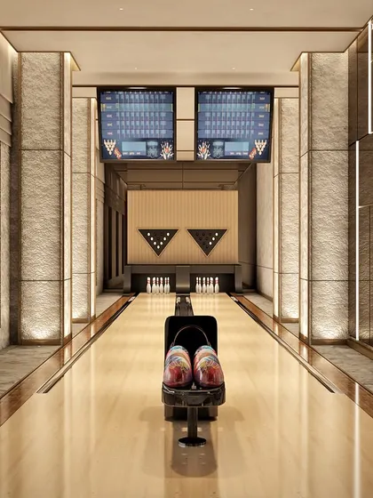 A state-of-the-art bowling alley with stunning city views. The design integrates modern aesthetics with practical luxury, using a harmonious blend of stone, metal, and wood to create a visually stunning and functional entertainment space.