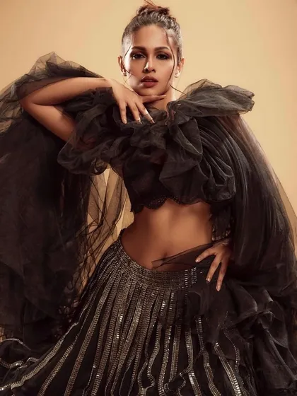 A showcase of high-fashion artistry with a dramatic black tulle ensemble. The makeup is powerful and sculpted, featuring a strong eye and defined features, ideal for a bride wanting a bold, avant-garde statement for her pre-wedding shoot or reception.