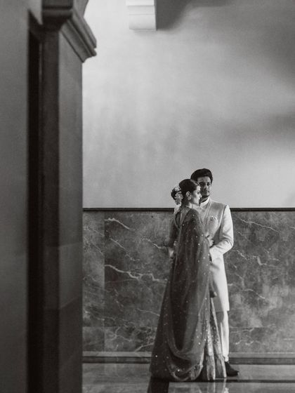 A distant black and white shot that emphasizes the grandeur of the architecture around the couple. It makes them part of a larger, timeless scene, adding a layer of artistic depth to their wedding portrait.