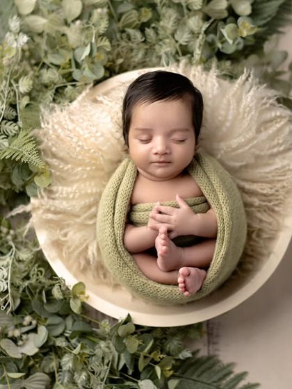A peaceful newborn surrounded by lush greenery. This setup brings a touch of nature indoors, highlighting the baby's serene and organic beauty.