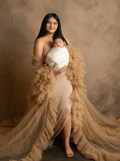 A stunning portrait of a new mother in a beautiful gown, holding her precious newborn. These sessions are a wonderful way to celebrate motherhood.