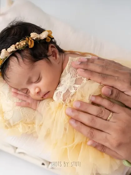A parent's gentle hand provides a sense of scale and security. This shot shows just how small and precious your newborn is, safely looked after.