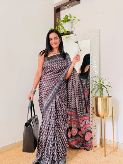 A grey and red printed saree that is both stylish and comfortable. It's a home-washable fabric, which makes it a practical choice for everyday workwear.