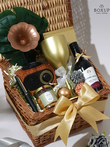 The 'Vintage Dreams' hamper is perfect for a classic, romantic theme. This wicker picnic basket is filled with a non-alcoholic wine, a vintage-style speaker, and other curated treasures.
