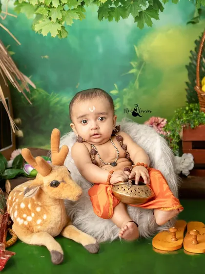 A regal pose from a baby dressed as Lord Ram, complete with traditional 'paduka' and a bowl. Every detail is considered in our cultural heritage photoshoots.
