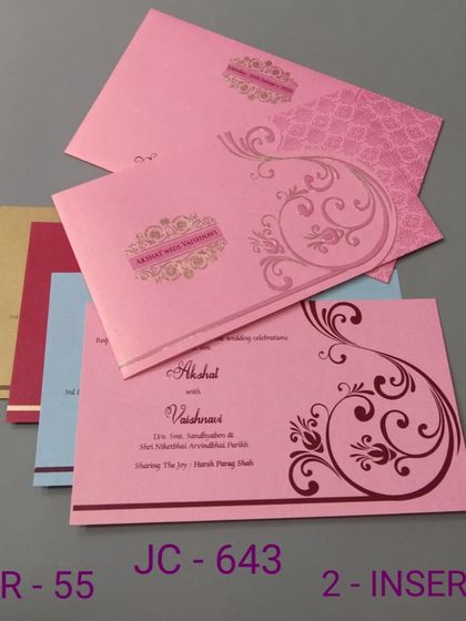 This pink invitation features a simple scroll design and comes with inserts in various colors. It's a budget-friendly and cheerful option for your wedding.