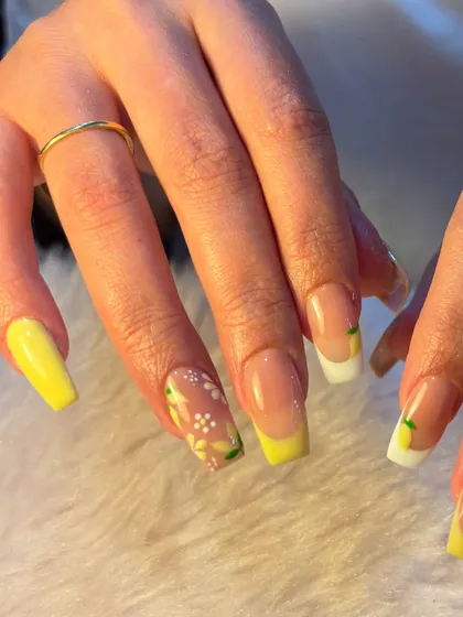 A fresh and zesty summer design. This set features a lemon-themed French manicure with hand-painted lemons and delicate white flowers on a sunny yellow base.