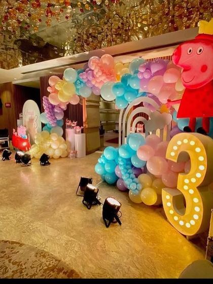 A large light-up number '3' and a Peppa Pig cutout at the entrance of the party hall, which features a stunning, ornate ceiling.
