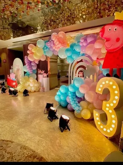 A large light-up number '3' and a Peppa Pig cutout at the entrance of the party hall, which features a stunning, ornate ceiling.