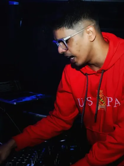 In a red hoodie, deep in concentration, making sure the music keeps people on the floor.