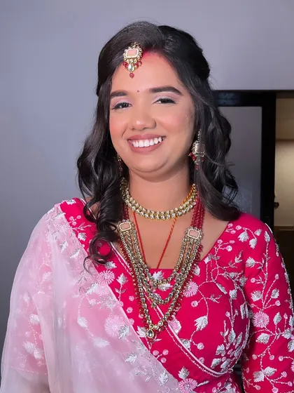 My beautiful bride Ayushi, glowing with elegance and grace for her reception. I created a look with soft, wavy hair and radiant makeup that complemented her vibrant pink outfit.