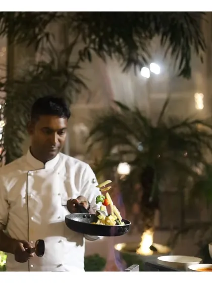 A chef puts the finishing touches on a plated dish with artistic flair. This image, a duplicate of ID 7, reinforces the theme of culinary craftsmanship at our live stations.