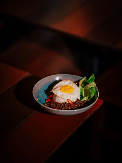 A comforting bowl of Krapow, minced meat with holy basil, served over rice with a perfect sunny-side-up egg. A taste of home, crafted with passion.