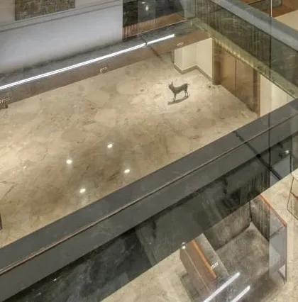 A view looking down through the glass bridge, showing how it creates visual connections between different floors.