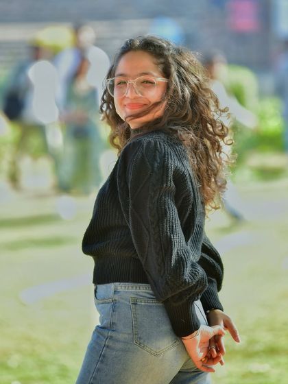 A candid moment with the wind blowing through her curly hair. This shot has a great sense of movement and captures a natural, unposed expression.