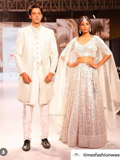 From the runway to your big day. I offer high-fashion, designer-inspired looks like this elegant all-white coordinated set, featuring a stunning cape-style lehenga for her and a chic sherwani for him.