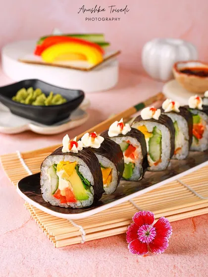 A full platter of the veggie sushi rolls, garnished with edible flowers. This shot showcases the dish as a shareable and beautiful platter.