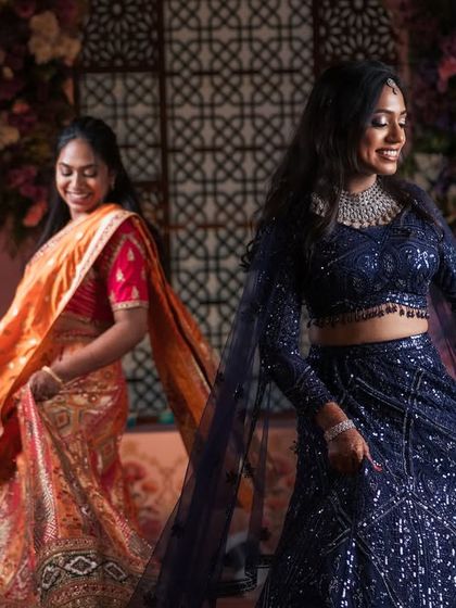A fun, candid moment of Dr. Akshara dancing with her sister. Her makeup and hair are designed to stay perfect even while she enjoys her celebration to the fullest.