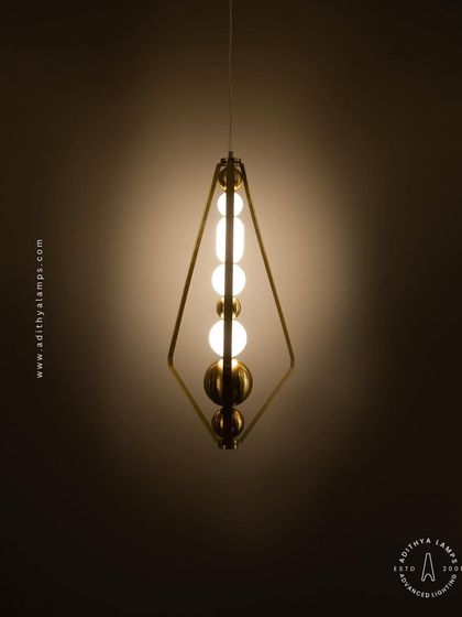 The triangular pendant light shown against a dark background, emphasizing its sculptural form and the warm light it emits. It's a perfect blend of geometric design and ambient lighting.