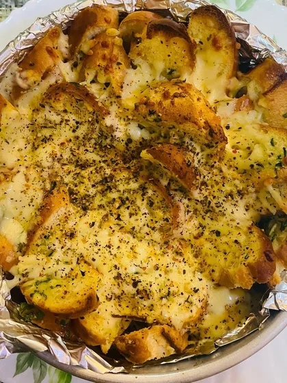 My cheesy garlic bread, baked until golden and bubbly. It's loaded with cheese and herbs, making it a warm, comforting, and irresistible savoury option for any event.