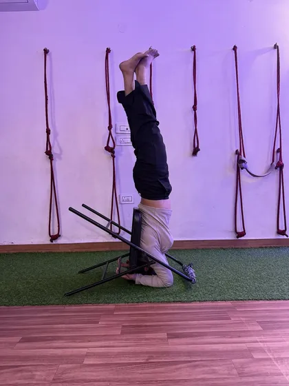 A supported headstand using a chair. This variation takes pressure off the neck and shoulders, making inversions more accessible.