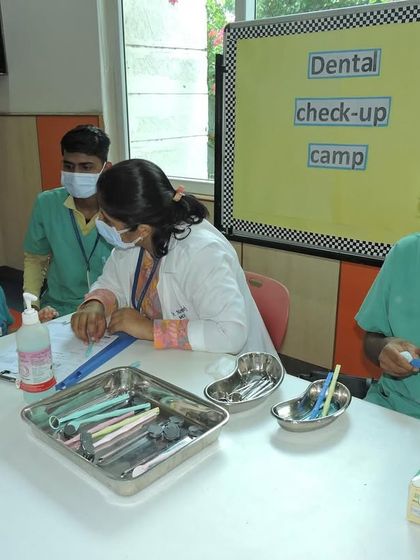A dentist speaks with a student after her check-up. These camps are a great opportunity to educate children about oral health and answer their questions.