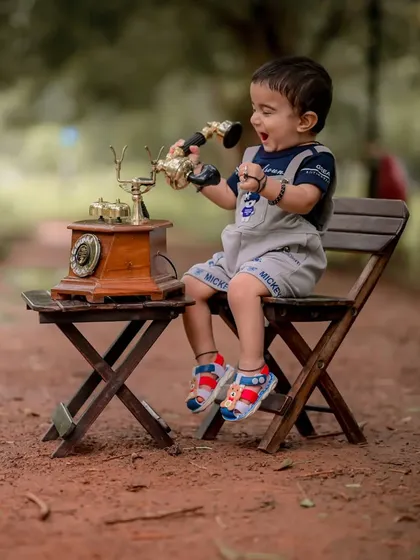 A moment of excitement and laughter as he speaks into the old-fashioned phone. Capturing these animated expressions is what makes candid baby photography so rewarding.