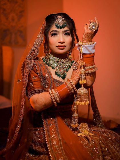 A full-body portrait of a bride holding her kalire, with dramatic lighting.