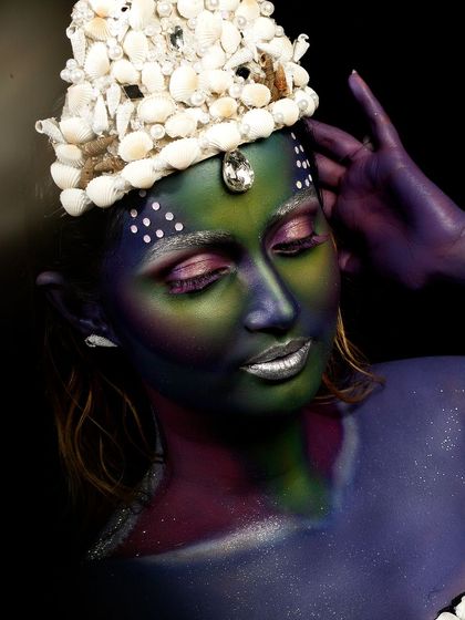 This creative portrait uses body paint and a custom seashell crown to evoke an underwater, mermaid-like theme. The lighting is used to create a deep-sea mood.
