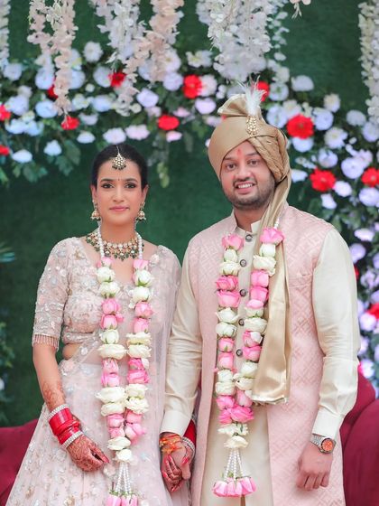 A classic portrait of the couple after their jaimala ceremony, posing for the camera.