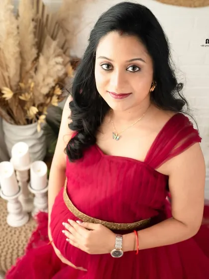A beautiful close-up portrait of the mom-to-be. Her direct gaze and gentle smile radiate confidence and happiness in this stunning red gown.