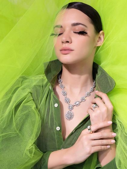 A solo shot from the IGI campaign, with the model enveloped in lime green tulle, creating a fresh, summery vibe for the diamond necklace.