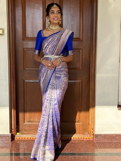 A full-length view of the stunning silver and blue Kanchivaram saree, showcasing its intricate weave and how the solid blue blouse provides a perfect balance.