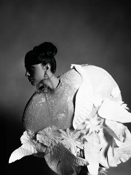 A black and white profile portrait for designer Rahul Mishra's collection, featured in Hindustan Times. This shot focuses on the sculptural quality of the garment and the model's strong silhouette, creating a dramatic, high-fashion editorial image.