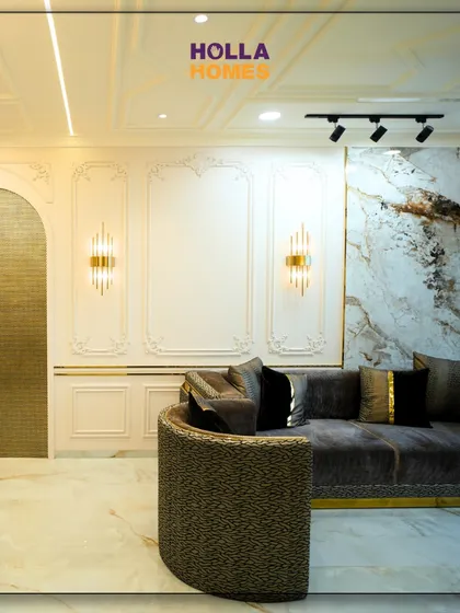 The beauty of Parisian design lies in the details. This shot highlights the classic wall mouldings, elegant wall sconces, and a stunning brass-finished door that add layers of texture and sophistication to the living space.