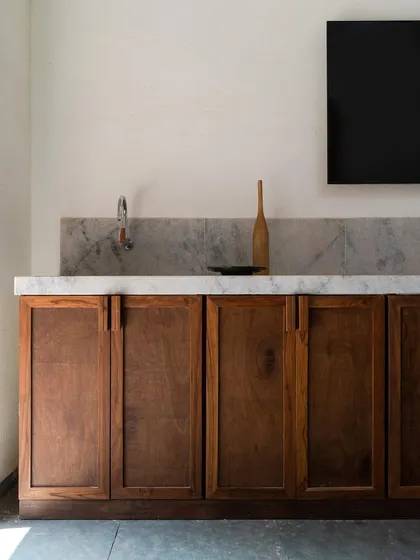 In Maison Rouge, we used reclaimed timber and local stone to create a rustic yet refined aesthetic. This simple wooden cabinet with a marble top exemplifies the project's balance of contemporary planning with traditional, vernacular materials.