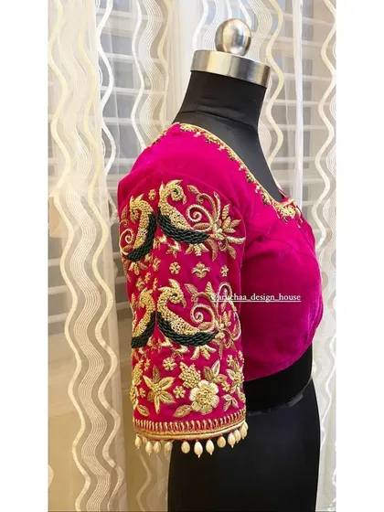 It's all in the details. A close look at the sleeve of a custom pink blouse, showcasing intricate zardosi and beadwork with peacock motifs, designed to make the entire outfit stand out.