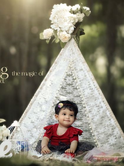 Capturing the magic of childhood. This little girl in her red dress is the center of attention in this enchanting outdoor teepee photoshoot.