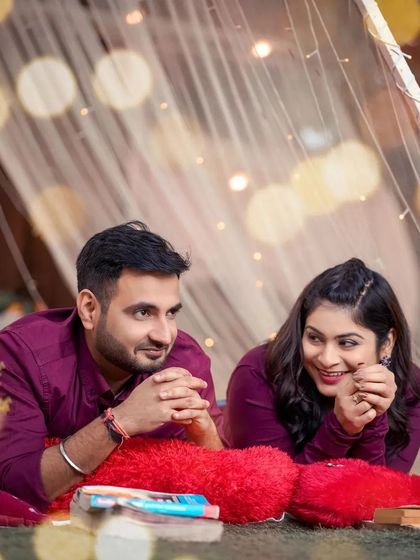 A cozy and intimate shot of a couple inside a tent decorated with fairy lights. The warm glow and close framing create a deeply romantic and personal pre-wedding photograph.