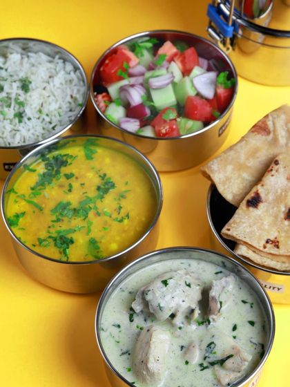 A classic non-veg tiffin with creamy white chicken curry, dal, rice, salad, and rotis. It's a lighter, flavorful option for a satisfying meal.