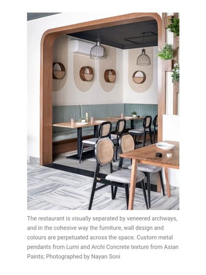 This image, featured in Elle Decor, highlights the cohesive design where furniture, wall treatments, and colors flow seamlessly. The custom metal pendants and textured walls add to the artisanal feel.