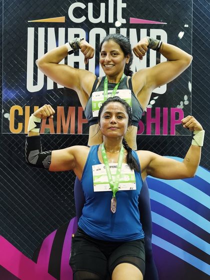 Flexing with my partner at the Cult Unbound Championship. This shows the fun and camaraderie of competing alongside other strong women.