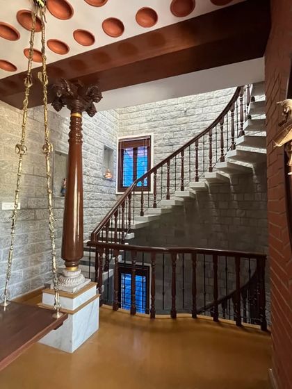 The indoor swing area, showing the graceful curve of the stone staircase and the traditional wooden pillar.