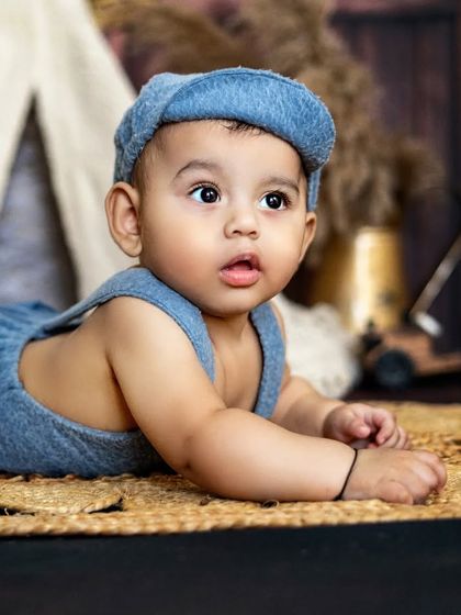 A curious little boy on his tummy time adventure. His wide eyes and sweet expression are perfectly captured in this rustic setting.