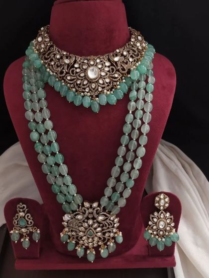 Another view of the pastel green Victorian set, highlighting the intricate metalwork and the quality of the stones and beads used in its creation.