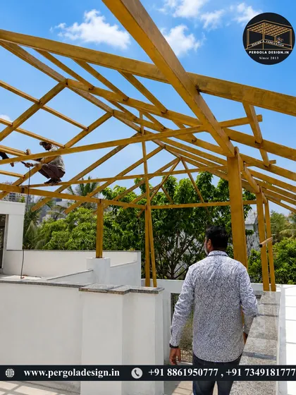 Our team at work on a rooftop, installing the wooden-finish steel frame for a large pergola structure.