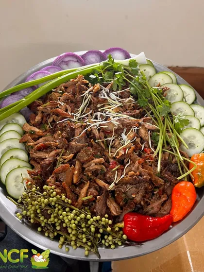A large platter of my spicy chicken salad, also known as chicken singju. It's garnished with fresh herbs, cucumbers, and fiery king chillies.
