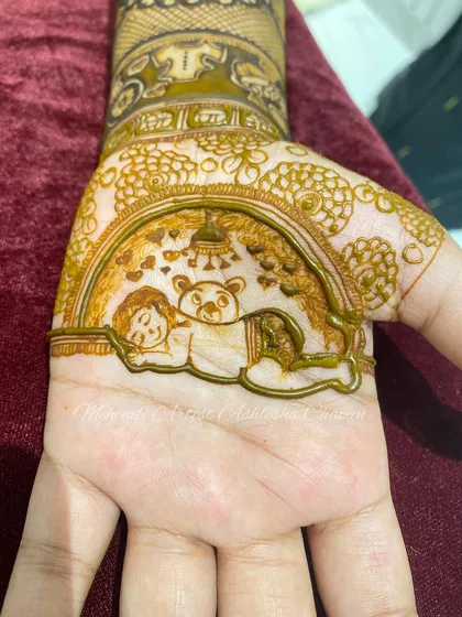 A close-up of a baby shower mehendi, featuring a sleeping baby with a teddy bear. It's a heartwarming and adorable design.