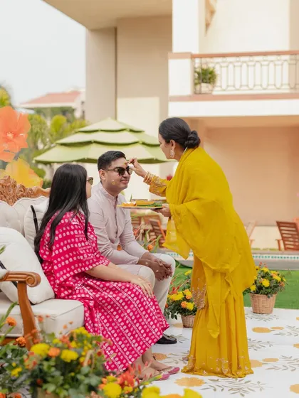 The Haldi rituals begin, with a family member applying the ceremonial tika to the groom.